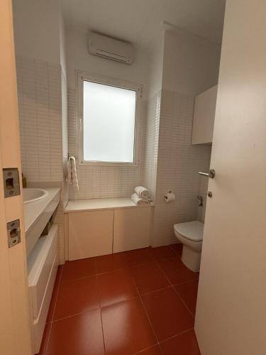 a bathroom with a tub and a toilet and a window at La COlectiva HOME in Xàtiva