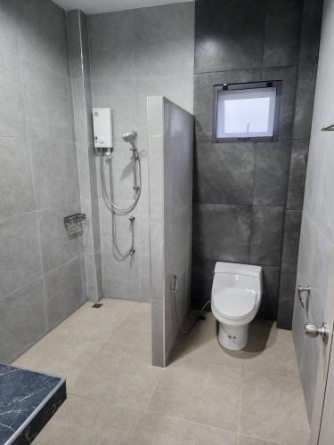 a bathroom with a toilet and a shower stall at Na-Tub House in Ban Nua