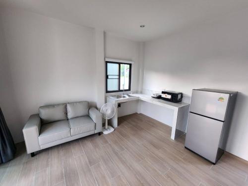 een woonkamer met een bank en een koelkast bij Na-Tub House in Ban Nua