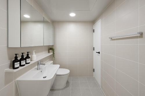 un bagno con lavandino, WC e specchio di 잠실명소 a Seul