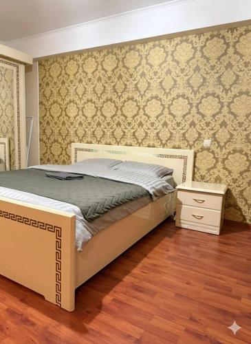 a bedroom with a bed and a wall at 1 комната для 2х человек центр парк in Chişinău