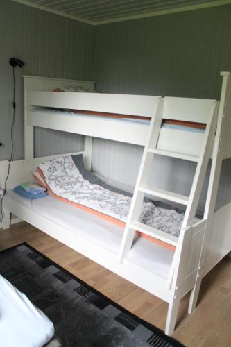 a white bunk bed with a ladder in a room at Svensby Tursenter in Svensby