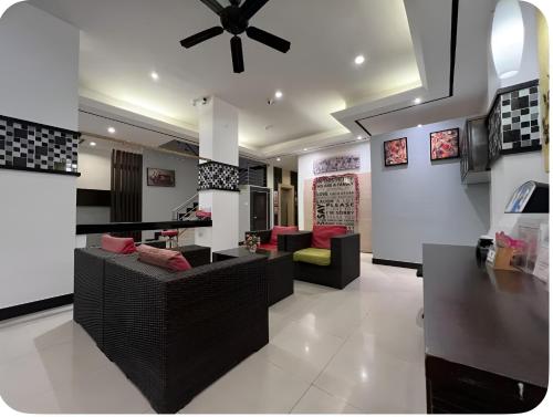 a living room with couches and a ceiling fan at Star House Patong in Patong Beach