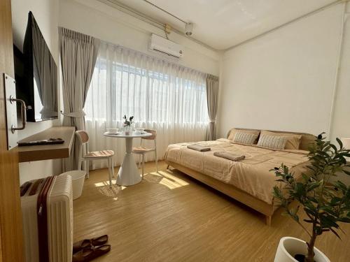 een slaapkamer met een bed en een tafel voor een raam bij Chatuchak Haus in Bangkok