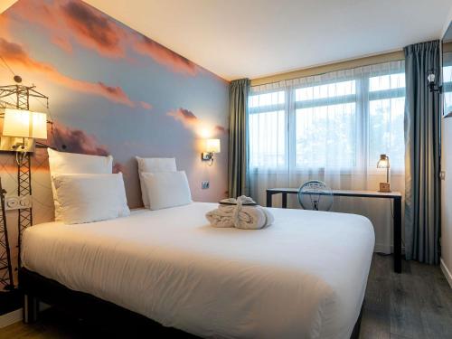 une chambre avec un grand lit blanc orné d'une fresque de nuages dans l'établissement Mercure Paris Malakoff Parc des Expositions, à Malakoff