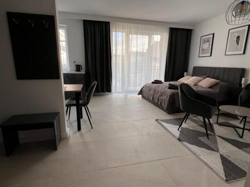 ein Schlafzimmer mit einem Bett, einem Tisch und Stühlen in der Unterkunft Apartamenty Wilenska in Słupsk