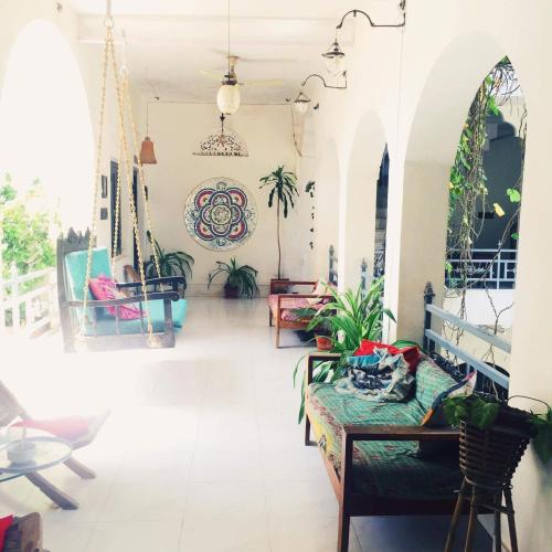 a living room with a couch and some plants at Inn Seventh Heaven in Pushkar