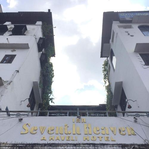 a sign for a travel hotel on the side of a building at Inn Seventh Heaven in Pushkar