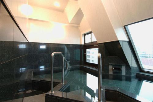 vestíbulo con suelo de cristal y escalera en Fuchu Urban Hotel, en Fuchu