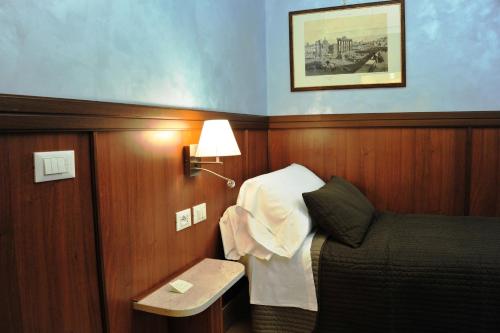 a small room with a bed and a lamp at Residenza Matteucci in Rome