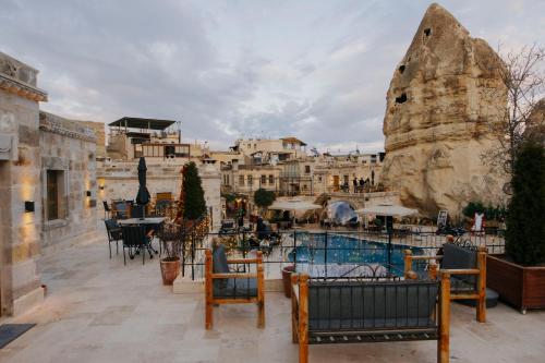 een resort met een zwembad en tafels en stoelen bij Göreme Cave Suites in Goreme