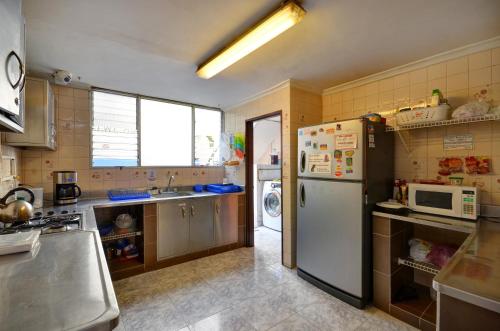 a kitchen with a refrigerator and a microwave at The Wandering Paisa in Medellín