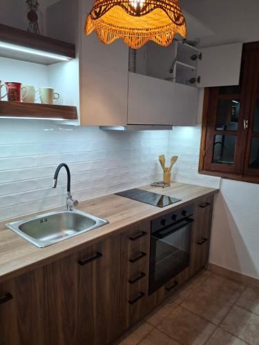 a kitchen with a sink and a stove and a light at Portitsa View Guesthouse in Spílaion