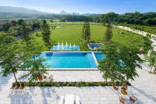 een uitzicht over een zwembad met stoelen en bomen bij Solmist Villa in Hòa Bình