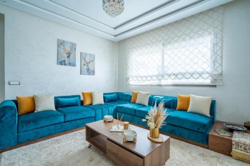 un soggiorno con un divano blu e un tavolino da caffè di Charming Flat with Pool view Fast Wi-Fi a Bouznika