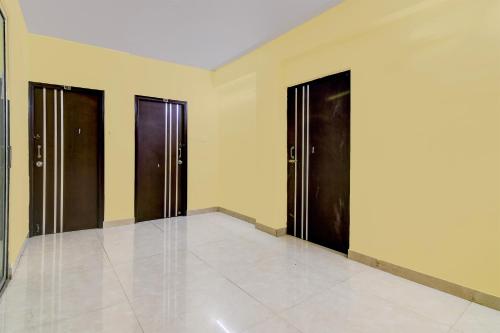 a hallway with three doors and a tile floor at Hotel O MAJESTIC M2 INN in New Town