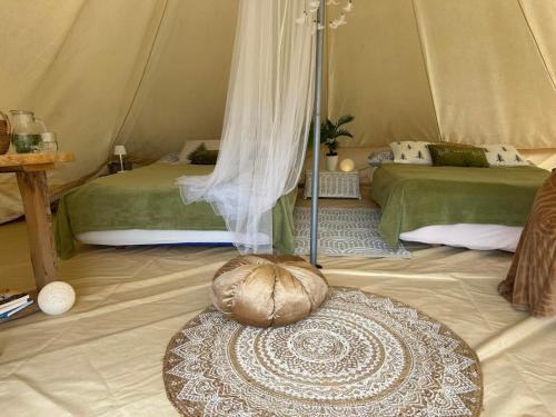 a room with two beds in a tent at Hillside Bio Glamping in Prebold