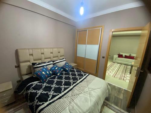 a bedroom with a large bed and a mirror at Casablanca City-Centre Apartment in Casablanca