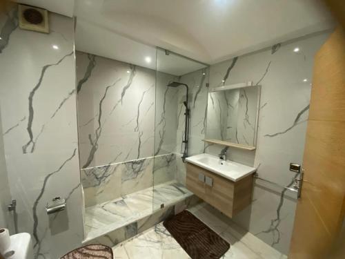 a bathroom with a shower and a sink and a mirror at Casablanca City-Centre Apartment in Casablanca
