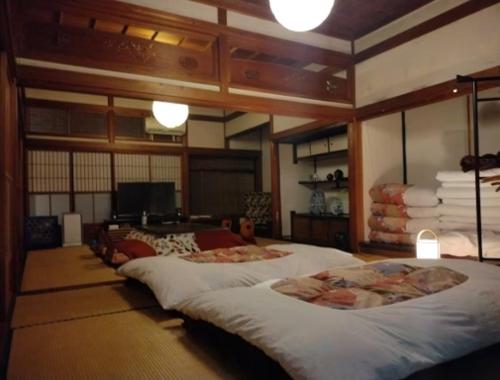 Giường trong phòng chung tại 囲炉裏のある築100年の一棟貸し古民家で昔の暮らし体験