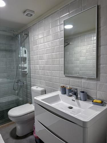 een badkamer met een wastafel, een toilet en een spiegel bij Haven46 