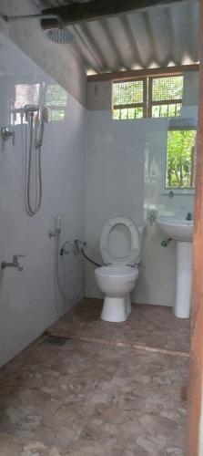 a bathroom with a toilet and a sink at Jungle Room in Talalla South