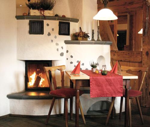 a dining room with a table and a fireplace at Gasthof Schönau in Heilsbronn