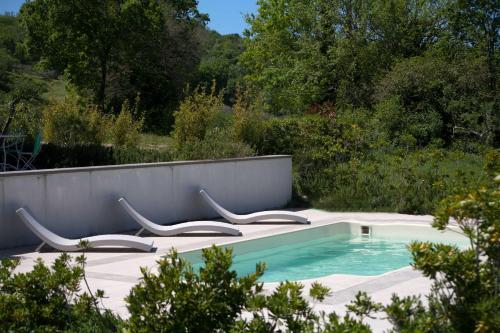 uma piscina com cadeiras num jardim em Villa Acquaviva em Montescudaio