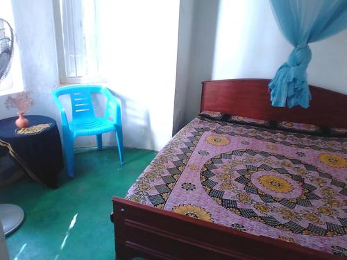 une chambre avec un lit et une chaise bleue dans l'établissement Brenley B Bungalow, à Talalla South