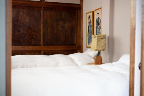 ein Schlafzimmer mit drei Betten und einem Kopfteil in der Unterkunft ROTAN東本町 Omura in Matsue