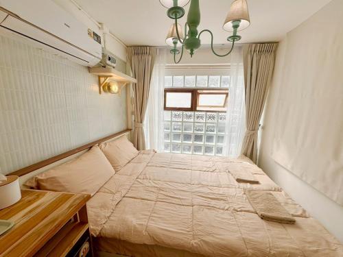 een slaapkamer met een bed voor een raam bij Chatuchak Haus in Bangkok