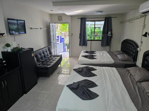 a bedroom with two beds and a couch at Sunflower Guesthouse in Karon Beach