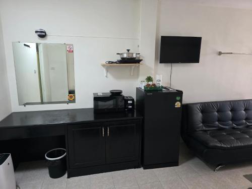 een kamer met een zwart bureau, een stoel en een spiegel bij Sunflower Guesthouse in Karon Beach