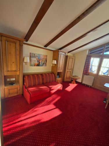 a living room with a red couch and a red carpet at Sonnhof Reit im Winkl in Reit im Winkl