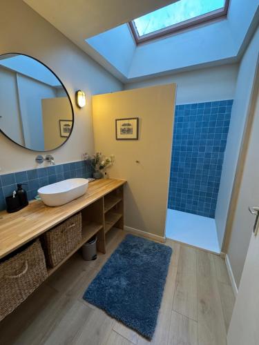 un bagno con lavandino e specchio di Les perdrix a Penmarch