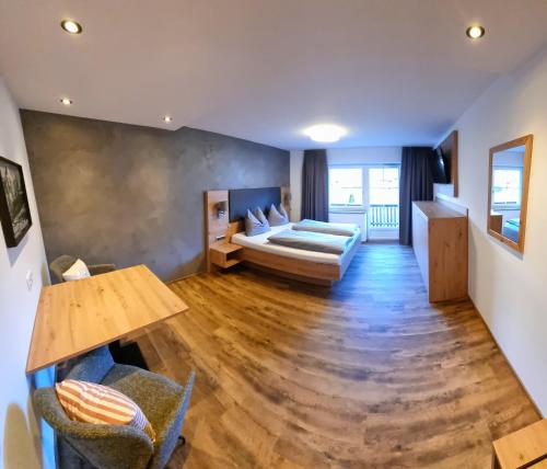 een woonkamer met een bed en een tafel bij B&B Gästehaus Alpenblick in Lermoos