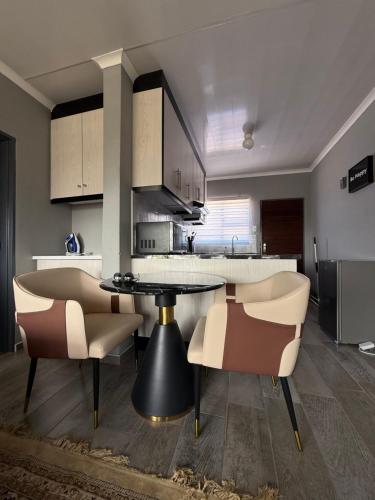 eine Küche mit Tisch und Stühlen in einem Zimmer in der Unterkunft The Residence Apartments in Maseru