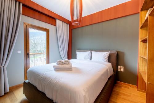 a bedroom with a bed with two towels on it at K Ardamis Estate in Kastoria
