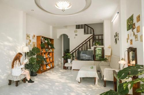 een vrouw in een stoel in een woonkamer bij Ichigo Home Đà Lạt in Da Lat