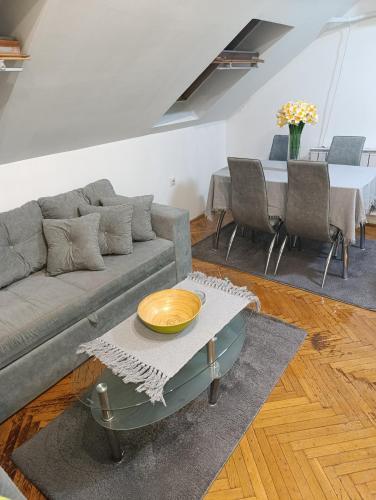 een woonkamer met een bank en een tafel bij Apartman 32 in Inđija