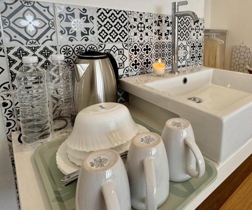 a kitchen counter with a sink and a tea set at Chatuchak Haus in Bangkok