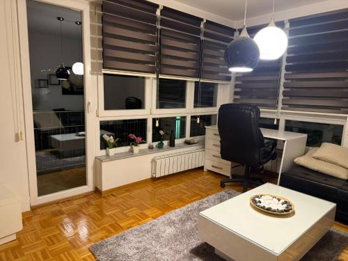 un salon avec un bureau et une chaise dans l'établissement Apartments Belma, à Sarajevo