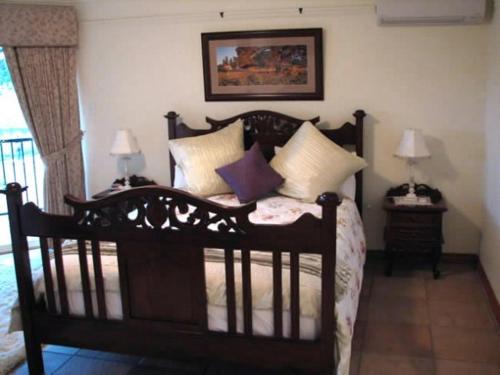 1 dormitorio con cama de madera y almohadas en Lakeview Lodge, en Stoneville