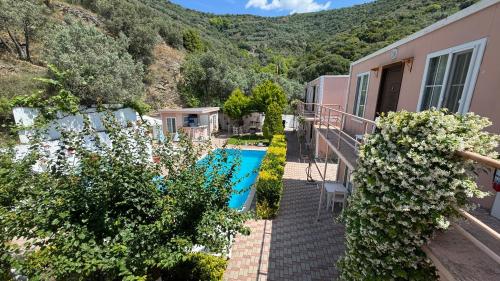 een huis met een zwembad en bergen op de achtergrond bij Ali Baba Butik Otel in Gündoğdu