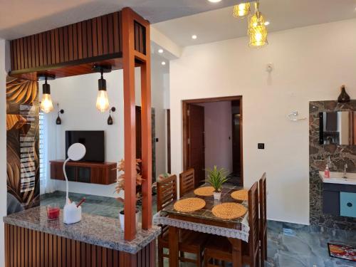 une salle à manger et une cuisine avec une table et des chaises dans l'établissement Riverbank Gardens, à Mananthavady
