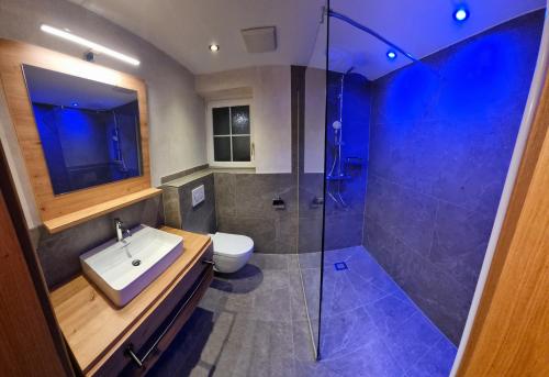 een badkamer met een wastafel en een douche bij B&B Gästehaus Alpenblick in Lermoos