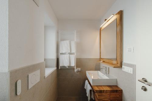 een badkamer met een wastafel en een spiegel bij Appartamento Piz Boe' in Arabba