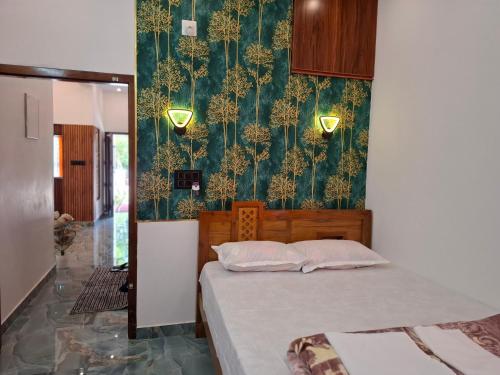 - une chambre avec un lit et un papier peint vert dans l'établissement Riverbank Gardens, à Mananthavady