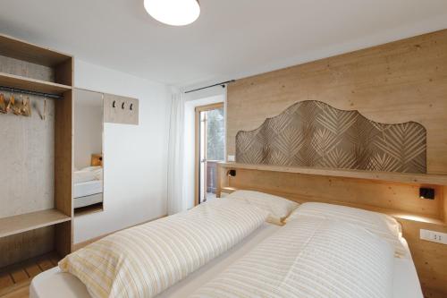 een slaapkamer met een bed met een groot houten hoofdeinde bij Appartamento Piz Boe' in Arabba
