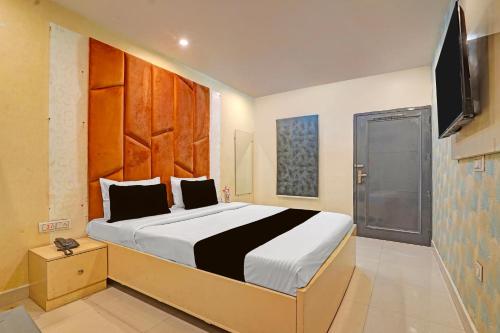 una camera da letto con un letto grande e una televisione di Hotel O Ace a Rohtak